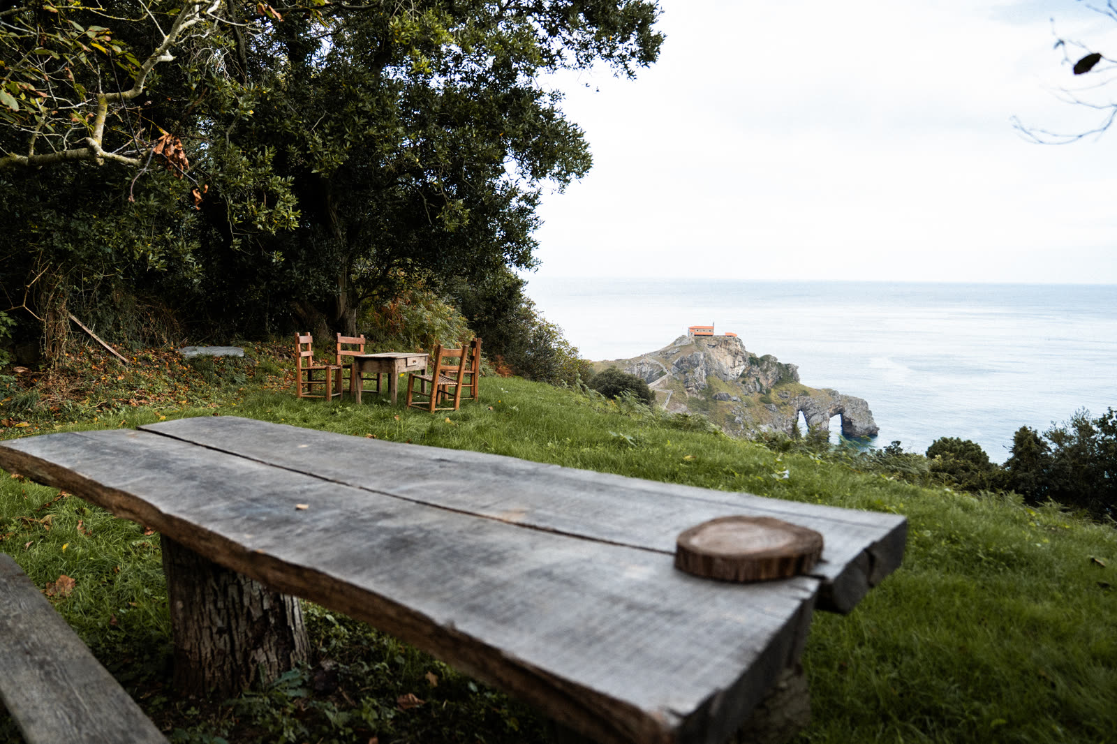Mesa de madera en el acantilado mirando a Gaztelugatxe