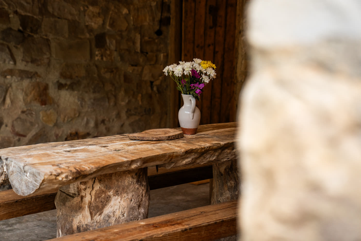 Mesa de piedra maciza con flores silvestres en el porche