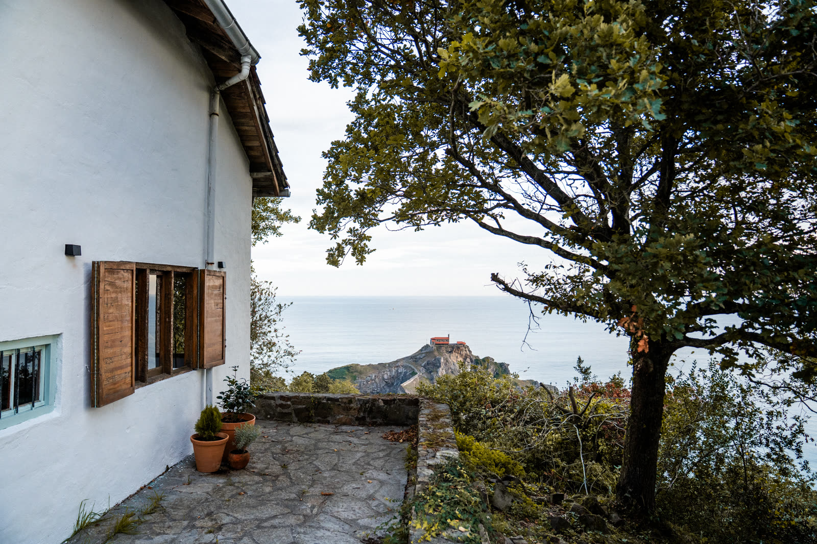 Ventana con contraventanas abiertas hacia San Juan de Gaztelugatxe
